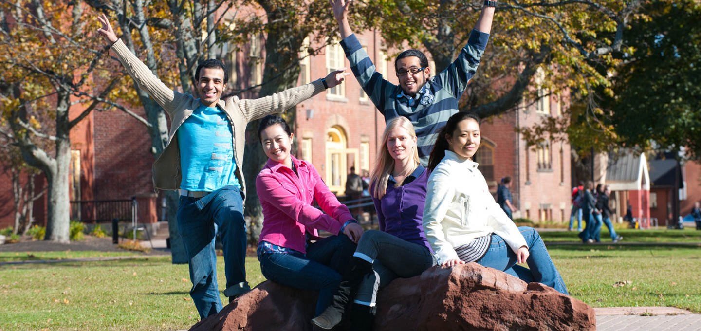 international students sitting in front of the university quad