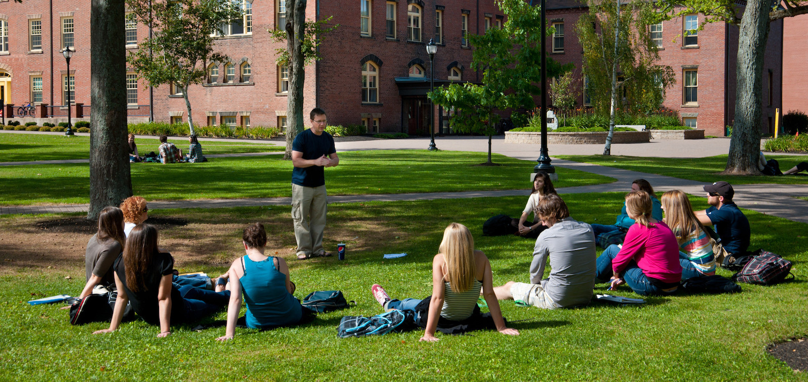 students listening to an outdoor lecture in the quad